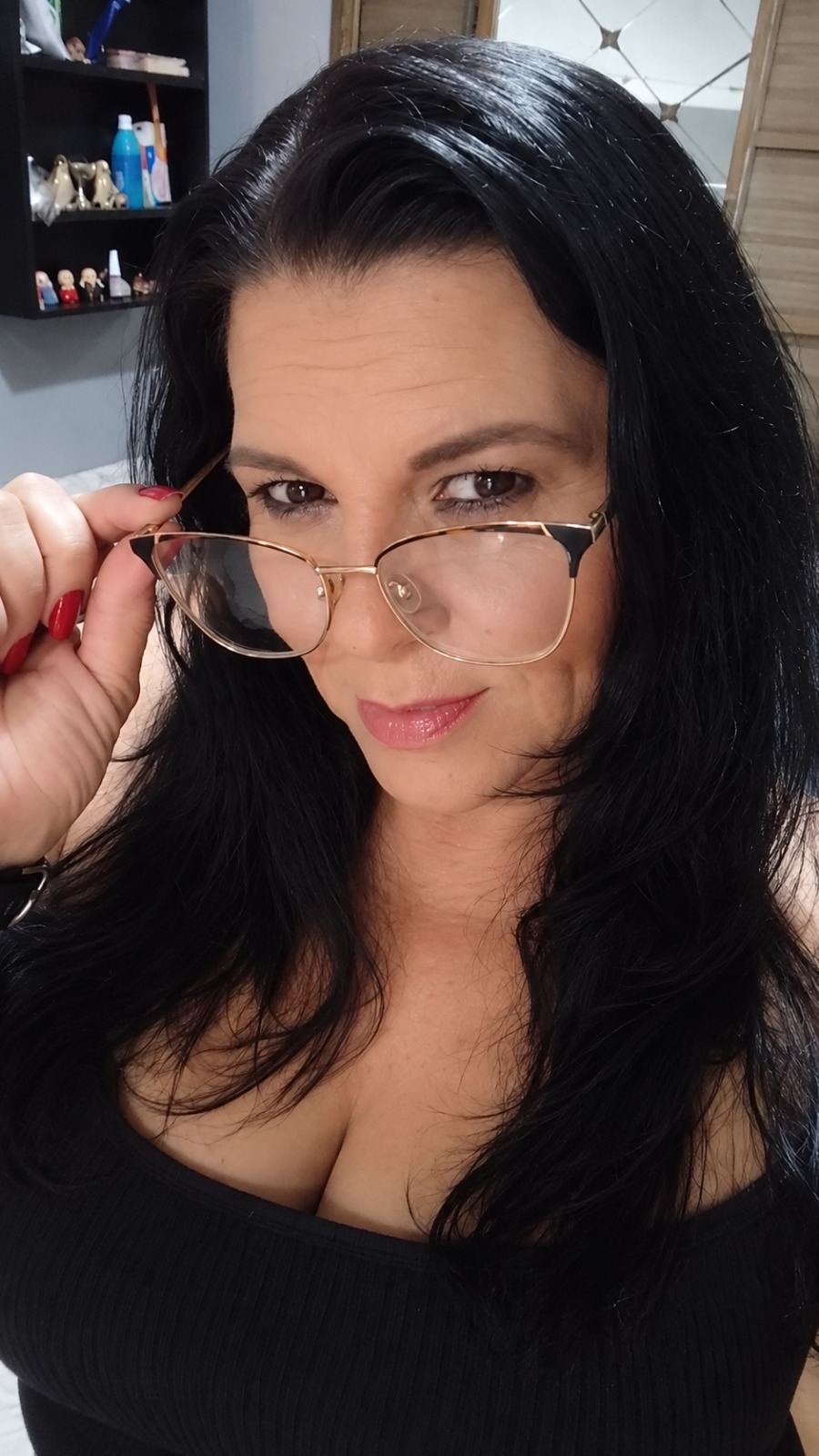 Retrato de Monique com óculos e blusa preta